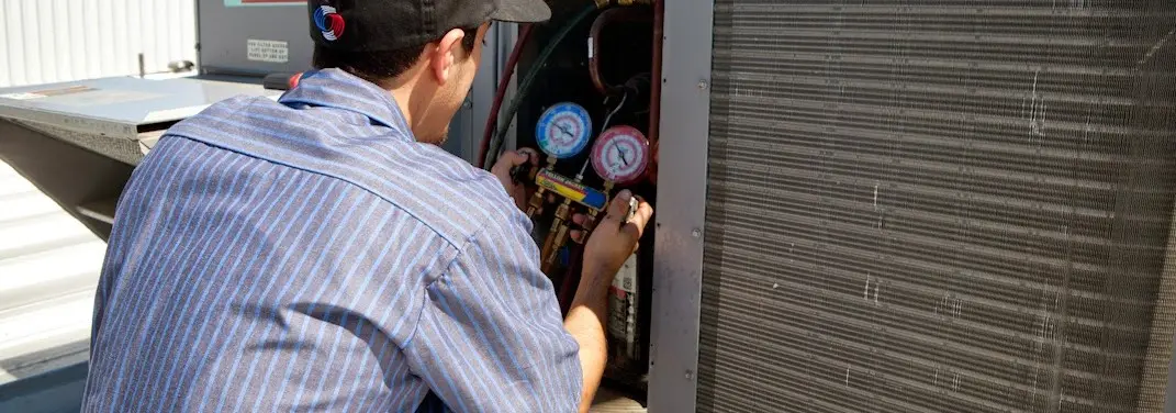 HVAC technician servicing a condenser unit in Brandermill