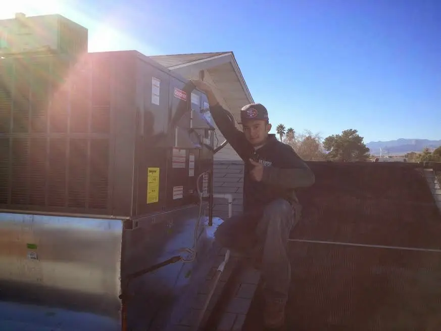 HVAC technician performing Air Duct Cleaning on a rooftop unit in Brandermill